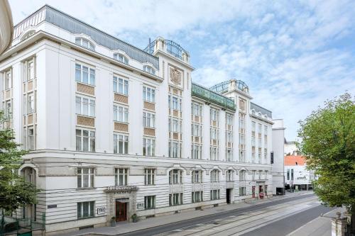 a white building on the side of a street at NH Wien Belvedere in Vienna