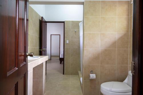 a bathroom with a toilet and a sink at Fuego del Sol Beachfront Hotel in Jacó