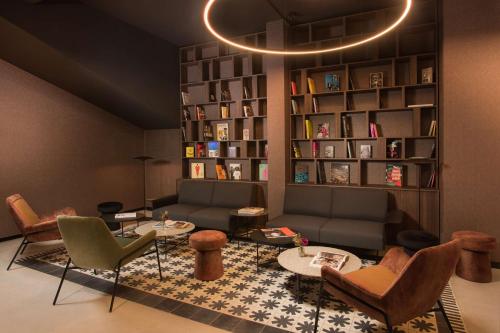 uma sala de estar com um sofá e uma estante de livros em NH Milano Corso Buenos Aires em Milão