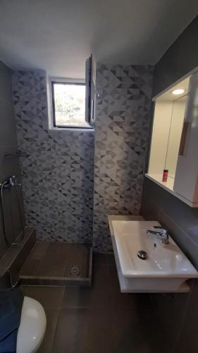 a bathroom with a sink and a toilet and a mirror at Sweet Home in Rethymno