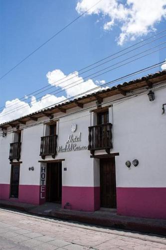 a white and pink building on a street at Hotel Real del Carmen - Ideal para familias y parejas in San Cristóbal de Las Casas