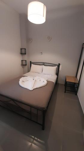 uma cama com lençóis brancos e almofadas num quarto em Sweet Home em Rethymno Town