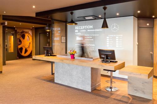 a reception desk with two computers on top of it at ibis Saint Dizier in Saint-Dizier