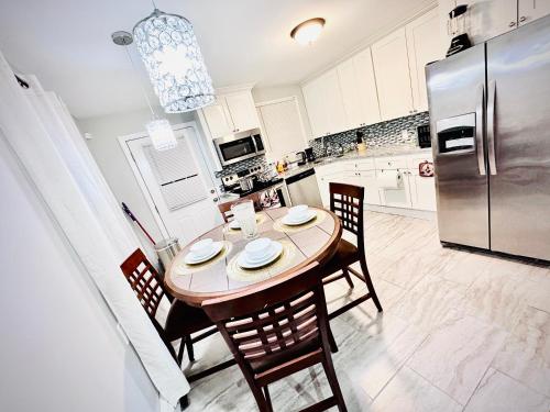 a kitchen with a table and chairs and a refrigerator at Peaceful home equal to a sound sleep! in Mastic Beach