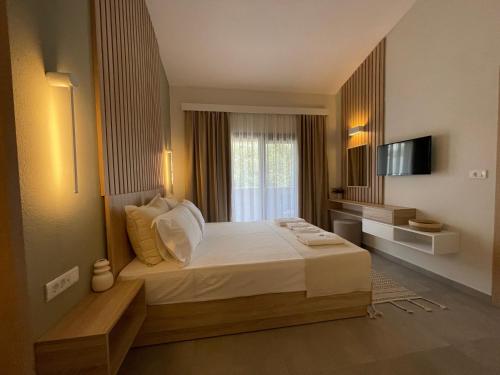 - une chambre avec un grand lit et une fenêtre dans l'établissement VERA VITA APARTMENTS, à Skala Rachoniou