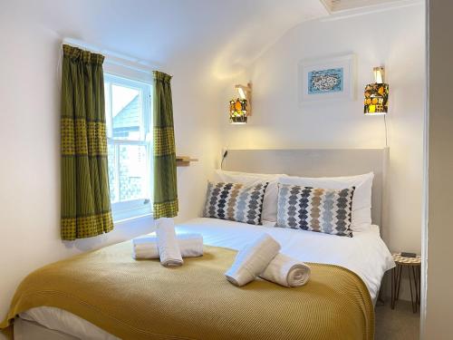 a bedroom with a bed with two towels on it at Sixpence Cottage, a few steps from the harbour! in St Ives