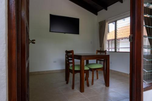 a dining room with a table and chairs and a television at Fuego del Sol Beachfront Hotel in Jacó