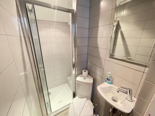 a bathroom with a shower and a toilet and a sink at Sixpence Cottage, a few steps from the harbour! in St Ives
