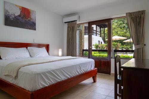 a bedroom with a large bed and a balcony at Fuego del Sol Beachfront Hotel in Jacó