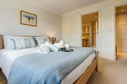 a bedroom with a large bed with blue sheets at Walnut Cottage in Brackley