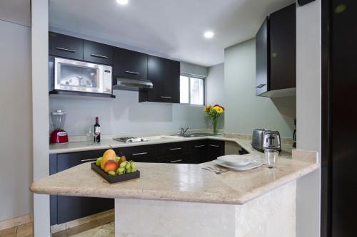 a kitchen with a counter with a bowl of fruit on it at Suites Parioli in Mexico City