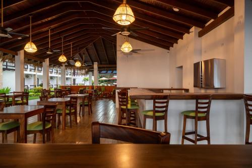 a restaurant with wooden tables and chairs and lights at Fuego del Sol Beachfront Hotel in Jacó