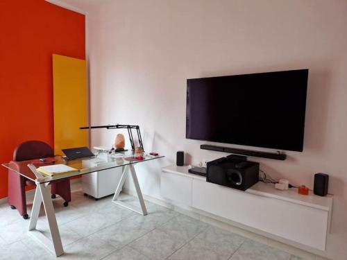 a living room with a desk and a television on a wall at Palazzo interno 3 in Giovinazzo