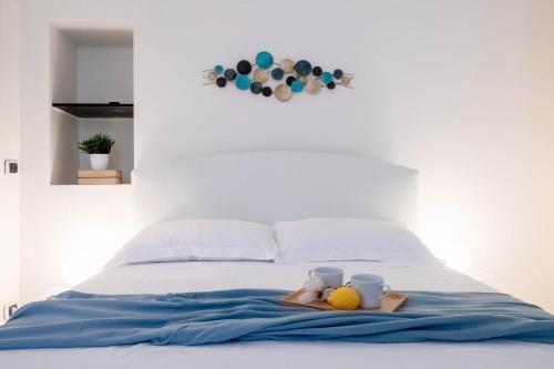 Una cama con dos tazas y una bandeja con dos frutas. en ALPORTO58, en Camogli