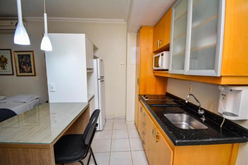 a small kitchen with a sink and a microwave at Garvey Park 1031 - Biensky Imóveis in Brasilia