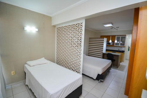 a hotel room with two beds and a kitchen at Garvey Park 1031 - Biensky Imóveis in Brasilia