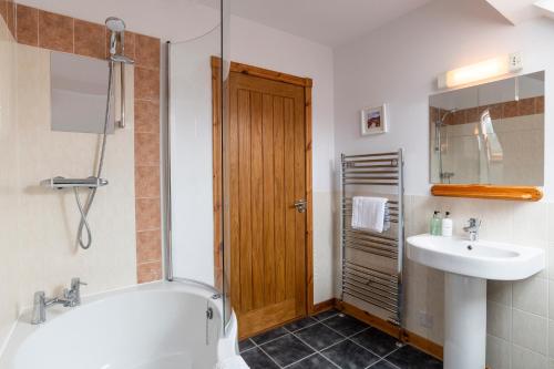un bagno con vasca e lavandino di Mountain View Lodge - Seasgair Lodges a Grantown on Spey