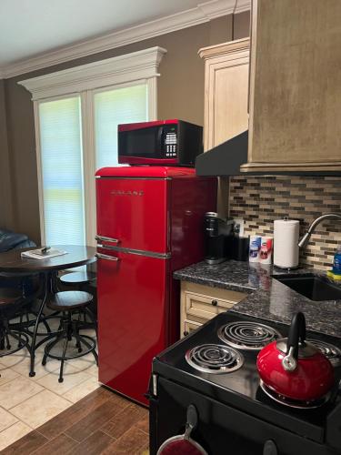 a red refrigerator in a kitchen with a table at West Wing at the Manor in Montgomery