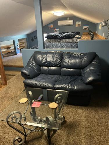 a black leather couch in a room with a bed at West Wing at the Manor in Montgomery