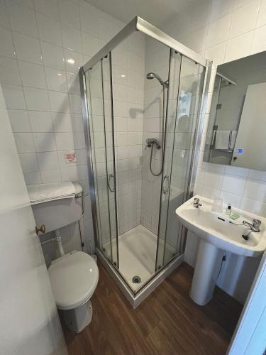 a bathroom with a shower and a toilet and a sink at Eastbourne Riviera Hotel in Eastbourne