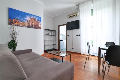 ein Wohnzimmer mit einem Sofa und einem Tisch in der Unterkunft PRESTIGE BOUTIQUE HOMES - Duomo 2 in Mailand