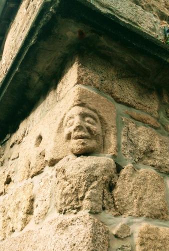 a stone statue of a face on the side of a building at Duplex au lin in Saint-Pol-de-Léon