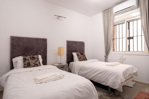 - une chambre avec 2 lits avec des draps blancs et une fenêtre dans l'établissement 29 Close to the beach, 2 bedroom Sabinillas Manilva Andalusia, à San Luis de Sabinillas