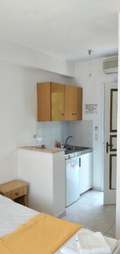 a white kitchen with a sink and a stove at Raymondos Apartments in Lassi