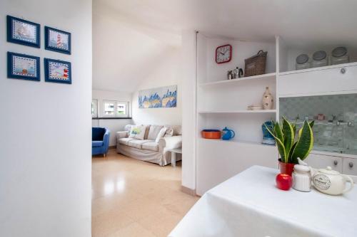 - un salon blanc avec une table et un canapé dans l'établissement APPARTAMENTO LA MANSARDINA, à Sestri Levante