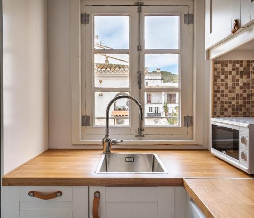 una cucina con lavandino e finestra di 2 Penthouse Duquesa Marina Manilva Andalucia Spanien a Manilva