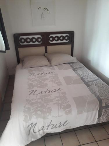 sypialnia z łóżkiem z białą kołdrą w obiekcie mini maison mini budget w mieście Soulac-sur-Mer