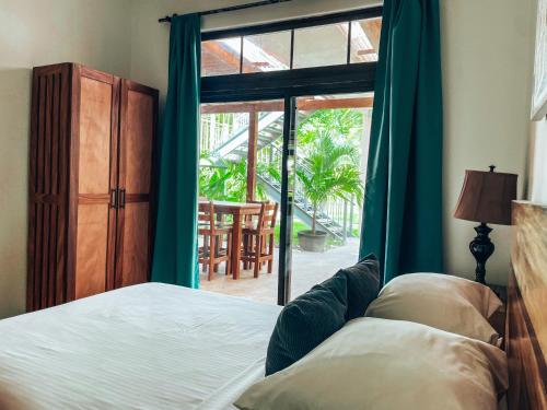 a bedroom with a bed and a sliding glass door at El Sitio Village in Playa Venao
