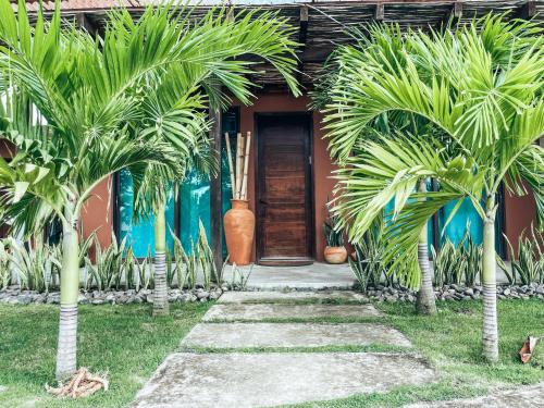 a house with palm trees in front of a door at El Sitio Village in Playa Venao