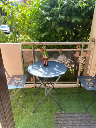 een tafel en 2 stoelen op een balkon bij Joli appartement meublé in Annecy