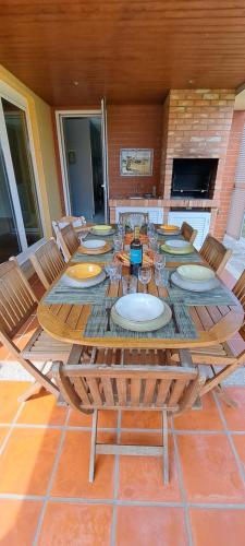 a table with chairs and plates on a patio at Villa Confort - FURADOURO in Ovar