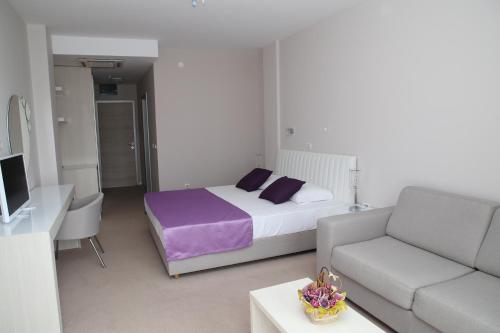 a living room with a bed and a couch at Hotel Ponta Nova in Budva