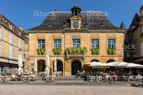 um edifício antigo com mesas e cadeiras em frente em Studio2 Fontaine de L'amour em Sarlat-la-Canéda