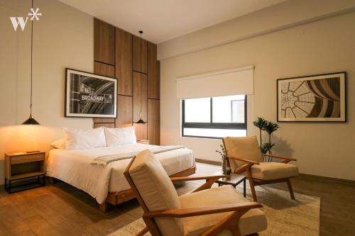 SoHo by Wynwood House في ليما: غرفة نوم بسرير وكرسيين ونافذة