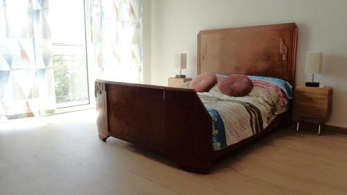 a bed with a large wooden headboard in a bedroom at Mieszkanie z kuchnią i łazienką in Augustów