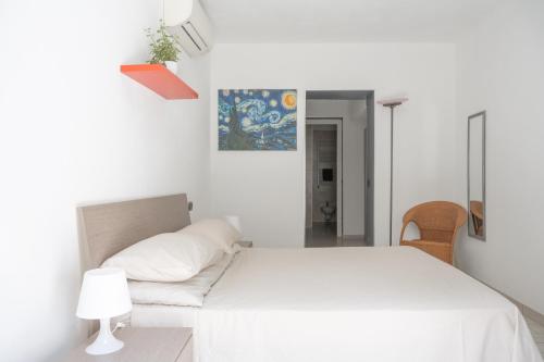 a white bedroom with a bed and a chair at Fabio's BnB in Milan