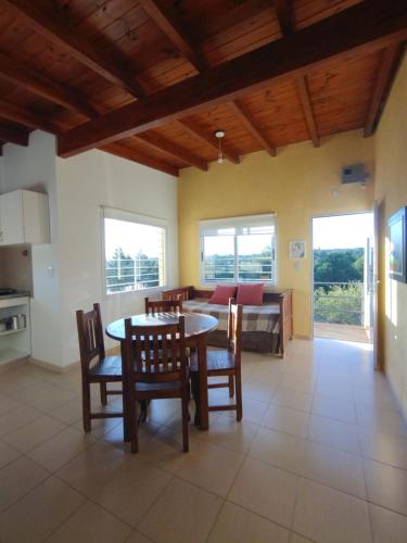 a kitchen and dining room with a table and chairs at El algarrobo escondido in La Falda