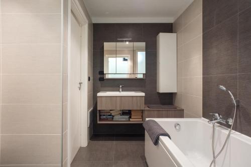 ein Badezimmer mit einer weißen Badewanne und einem Waschbecken in der Unterkunft Fabio's BnB in Mailand