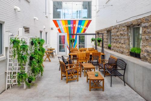 un patio con mesas y sillas y una sombrilla de arco iris en The Gallatin, en Nashville