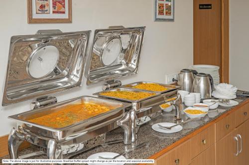 a kitchen counter with two trays of food at Treebo Mall View, DLF Phase II in Gurgaon