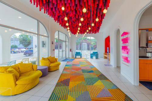 a lobby with yellow chairs and red chandeliers at The Gallatin in Nashville