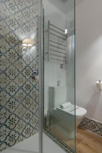 a bathroom with a toilet and a glass shower at H-A Aparthotel Hotel Quo in Madrid