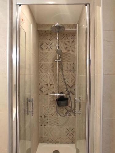 une douche avec une porte vitrée dans une salle de bain dans l'établissement Maison studio Le Crotoy proche plage et centre ville, au Crotoy