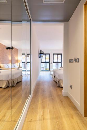 a bedroom with two beds and a glass wall at H-A Aparthotel Hotel Quo in Madrid