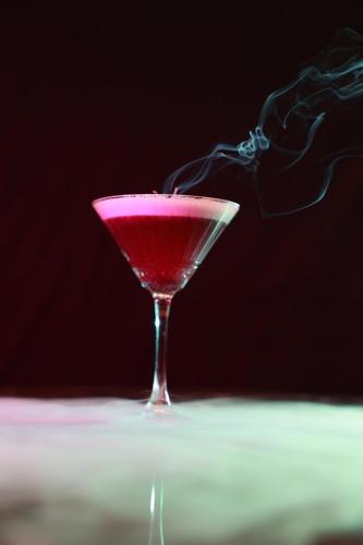 uma bebida rosa num copo de martini sobre uma mesa em Serenity Queen Hotel em Alanya