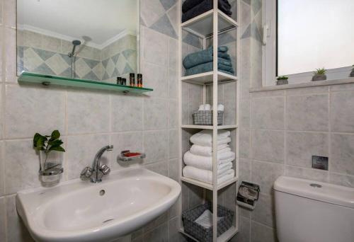 bagno con lavandino, specchio e asciugamani di Easy Living City Apartment a Chania